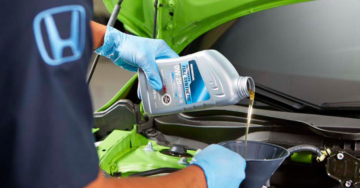 Technician changing oil to improve Honda fuel efficiency