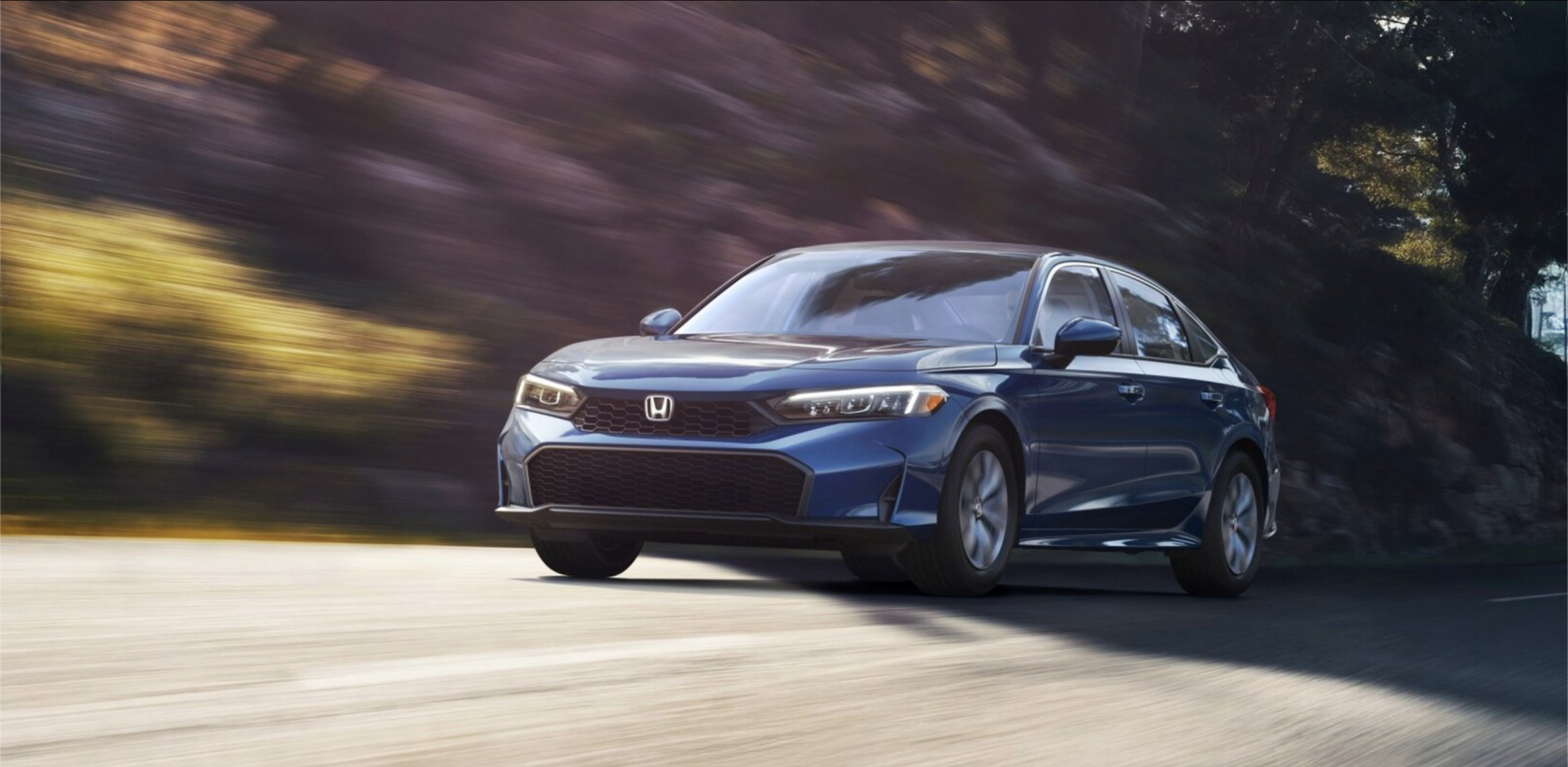 A Honda sedan driving in the city