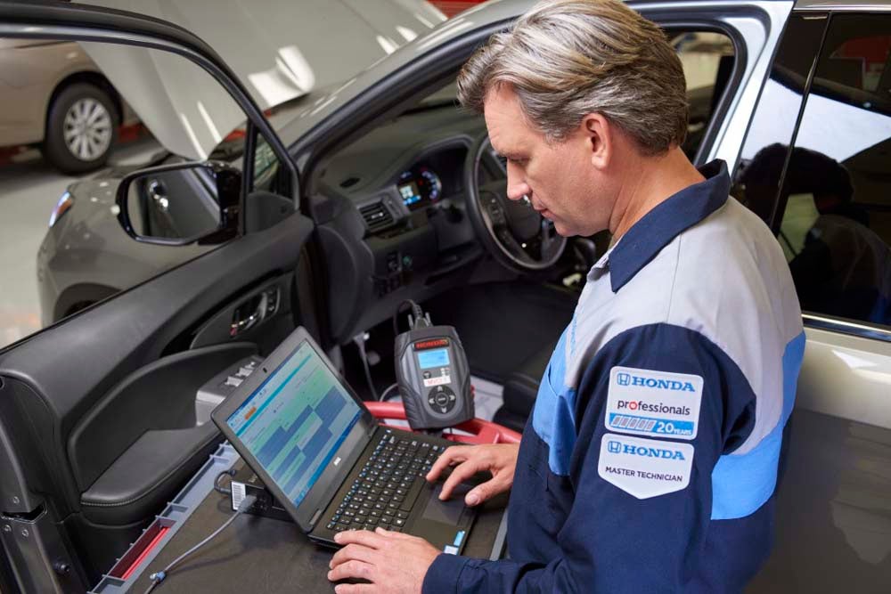 Certified Honda service technician performing diagnostics