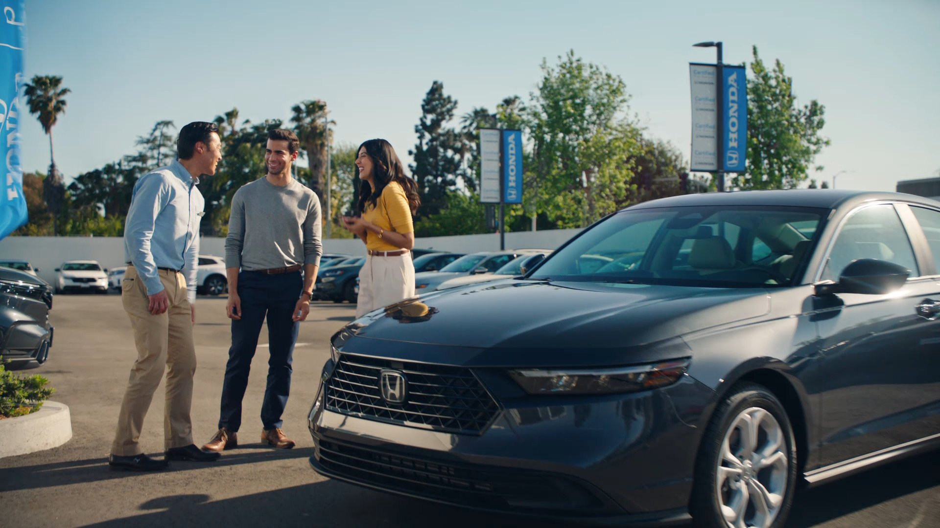 Excited customers buying a certified pre-owned Honda sedan